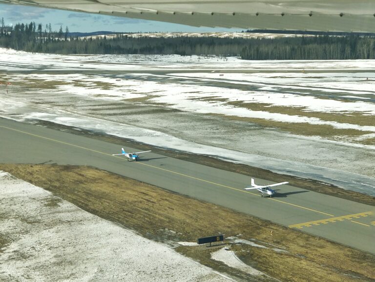 Two airplanes hold short of runway